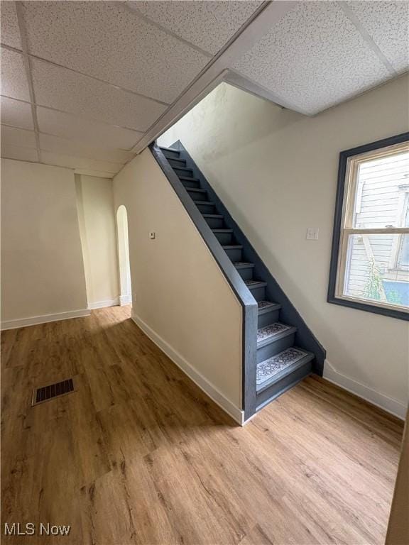1019 Commerce St, Wellsville, OH 43968 - below grade area featuring arched walkways, a drop ceiling, wood finished floors, and stairway