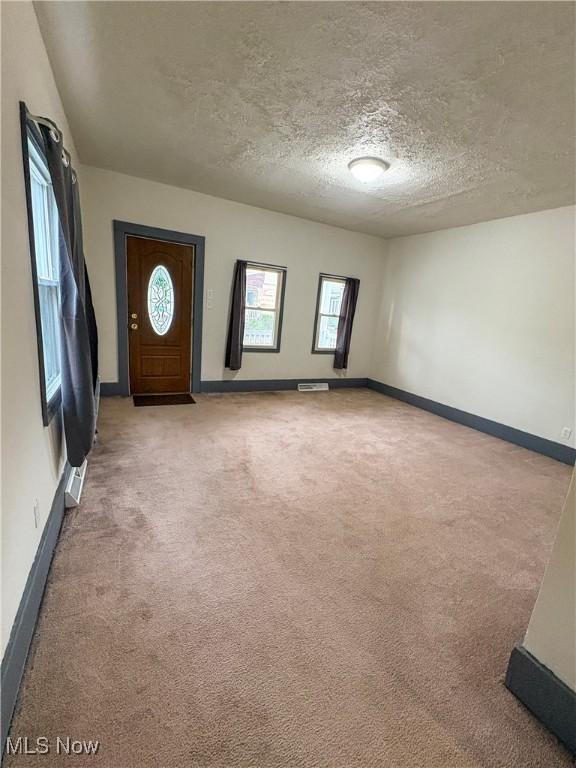 1019 Commerce St, Wellsville, OH 43968 - carpeted foyer featuring a textured ceiling and baseboards