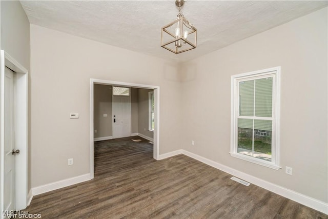 190 Columbus St, Chagrin Falls, OH 44022 - empty room featuring a chandelier, dark wood-type flooring, baseboards, and a textured ceiling