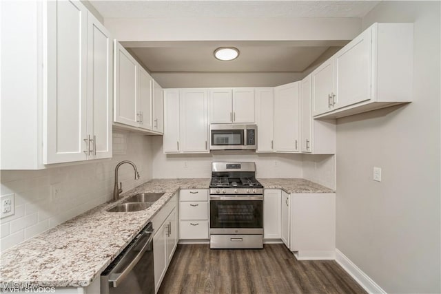 190 Columbus St, Chagrin Falls, OH 44022 - kitchen featuring appliances with stainless steel finishes, a sink, dark wood-style flooring, white cabinets, and backsplash