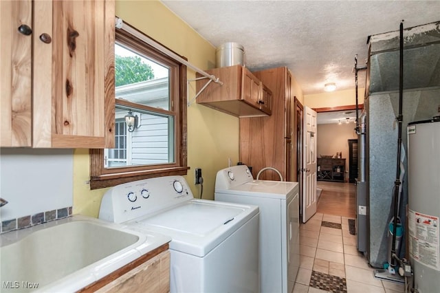 5081 Middle Ridge Rd, Perry, OH 44081 - laundry room with independent washer and dryer, light tile patterned floors, water heater, cabinet space, and a textured ceiling