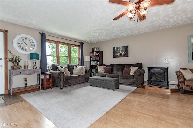5081 Middle Ridge Rd, Perry, OH 44081 - living area with ceiling fan, a textured ceiling, wood finished floors, and a wood stove