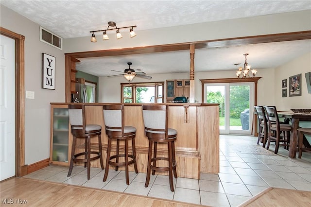 5081 Middle Ridge Rd, Perry, OH 44081 - kitchen featuring plenty of natural light, a breakfast bar, a peninsula, a ceiling fan, and a textured ceiling