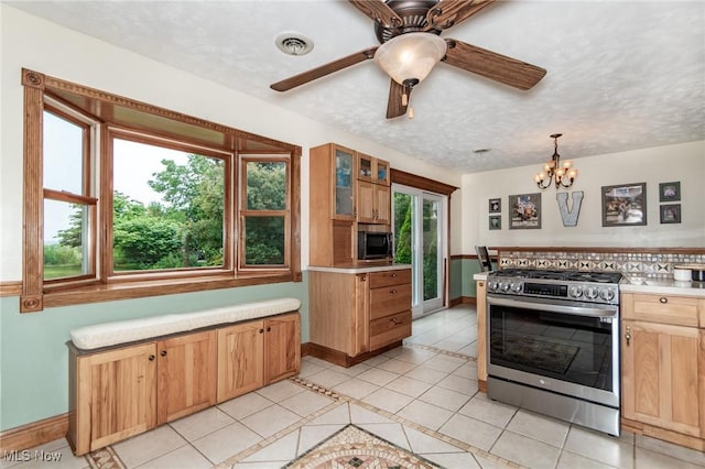 5081 Middle Ridge Rd, Perry, OH 44081 - kitchen with stainless steel gas stove, black microwave, baseboards, light tile patterned floors, and light countertops