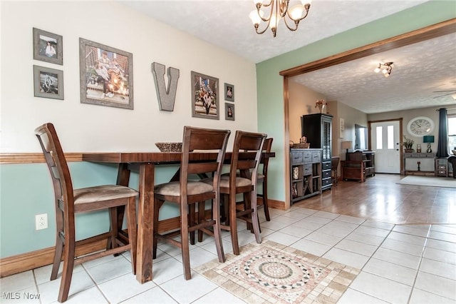 5081 Middle Ridge Rd, Perry, OH 44081 - dining space featuring a chandelier, light tile patterned floors, a textured ceiling, and baseboards
