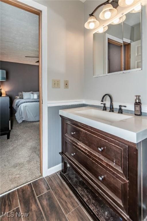 5081 Middle Ridge Rd, Perry, OH 44081 - bathroom featuring vanity, a wainscoted wall, wood finished floors, and ensuite bathroom