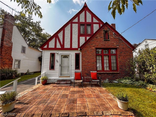 31 Marlindale Ave, Boardman, OH 44512 - rear view of house featuring brick siding, a chimney, a patio area, and a yard