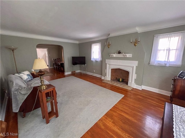 31 Marlindale Ave, Boardman, OH 44512 - living room featuring crown molding, arched walkways, wood finished floors, a fireplace with flush hearth, and baseboards