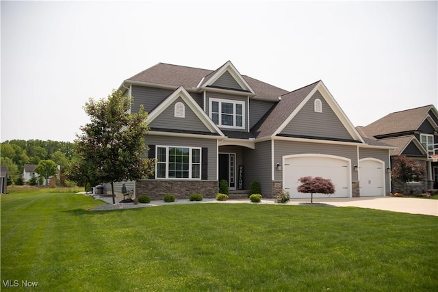 8224 Lilly Ln, Concord, OH 44077 - craftsman house with driveway, a front yard, stone siding, an attached garage, and roof with shingles