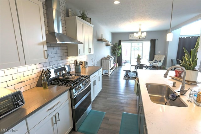 8224 Lilly Ln, Concord, OH 44077 - kitchen featuring wall chimney exhaust hood, stainless steel range with gas stovetop, a sink, a chandelier, and tasteful backsplash