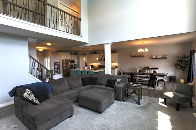 8224 Lilly Ln, Concord, OH 44077 - living area featuring ornate columns, wood finished floors, stairs, a towering ceiling, and a chandelier
