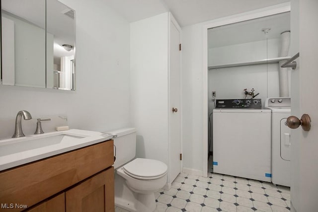 800 Brick Mill Run Unit 103, Westlake, OH 44145 - bathroom with washer and clothes dryer, toilet, vanity, tile patterned floors, and baseboards