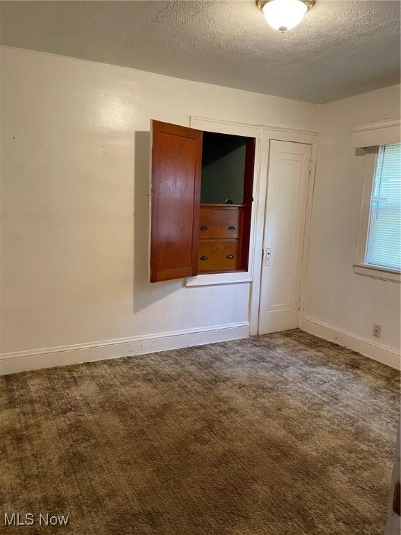 772 Shoshone Ave, Akron, OH 44305 - empty room with a textured ceiling and carpet