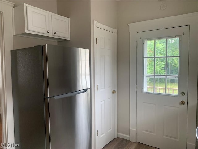 3961 E 53rd St, Newburgh Heights, OH 44105 - kitchen featuring freestanding refrigerator, light wood-style flooring, white cabinetry, and baseboards