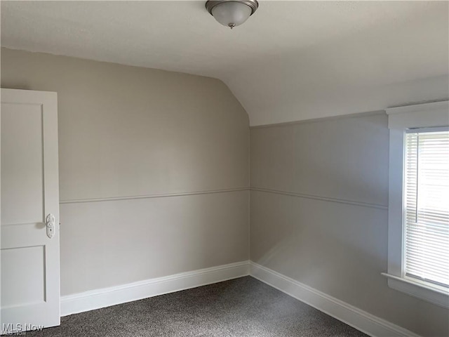 3961 E 53rd St, Newburgh Heights, OH 44105 - additional living space featuring vaulted ceiling, dark carpet, and baseboards