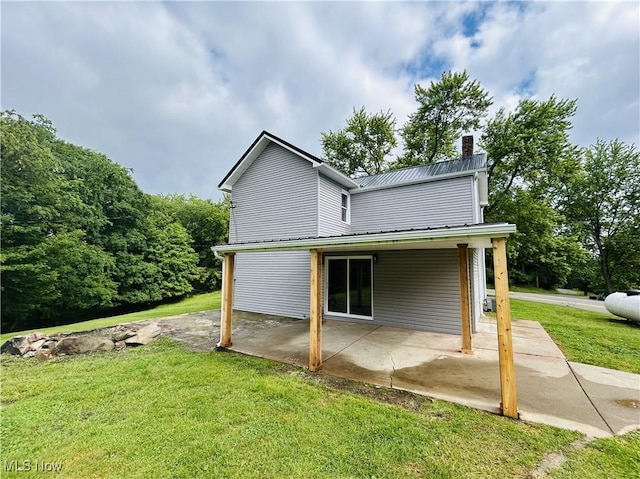 2815 Race Track Rd, New Cumberland, WV 26047 - view of home's exterior featuring a patio, a yard, a chimney, and metal roof