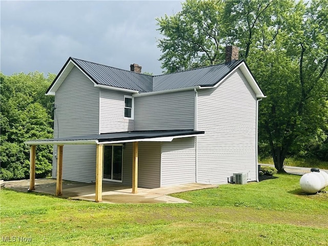 2815 Race Track Rd, New Cumberland, WV 26047 - rear view of house with a chimney, a patio area, a yard, cooling unit, and metal roof