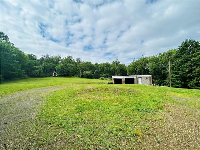 2815 Race Track Rd, New Cumberland, WV 26047 - view of green lawn featuring a pole building, a detached garage, a forest view, and an outdoor structure