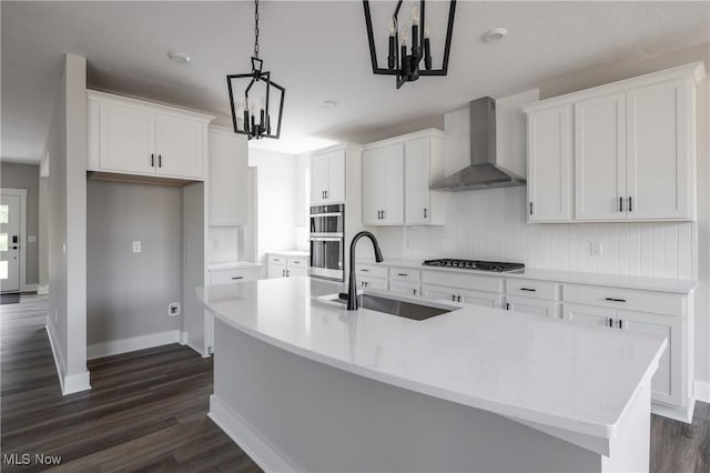 3730 Overlook Ct, Akron, OH 44333 - kitchen featuring wall chimney exhaust hood, a chandelier, dark wood finished floors, white cabinets, and a kitchen island with sink
