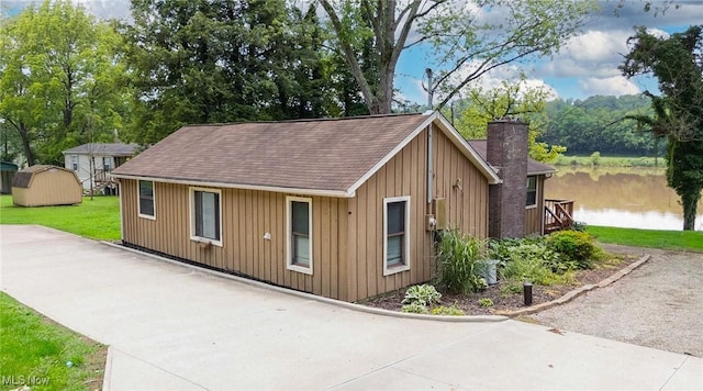 15225 State Route 60, Lowell, OH 45744 - view of front of house with board and batten siding, a front lawn, a shingled roof, and a chimney
