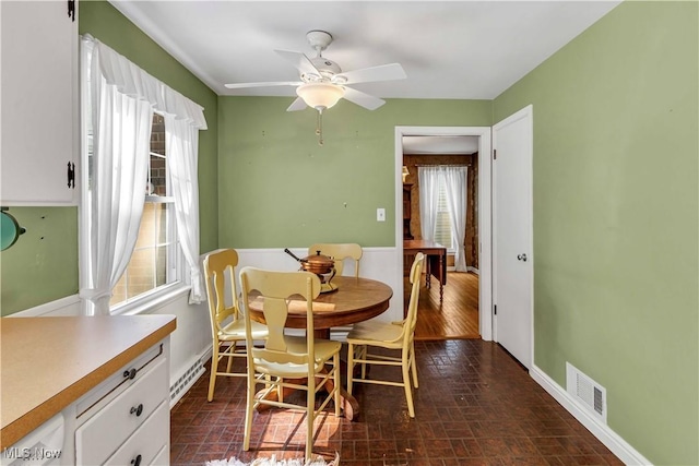 1783 Maywood Rd, South Euclid, OH 44121 - dining area with brick patterned floors, a ceiling fan, baseboards, and baseboard heating
