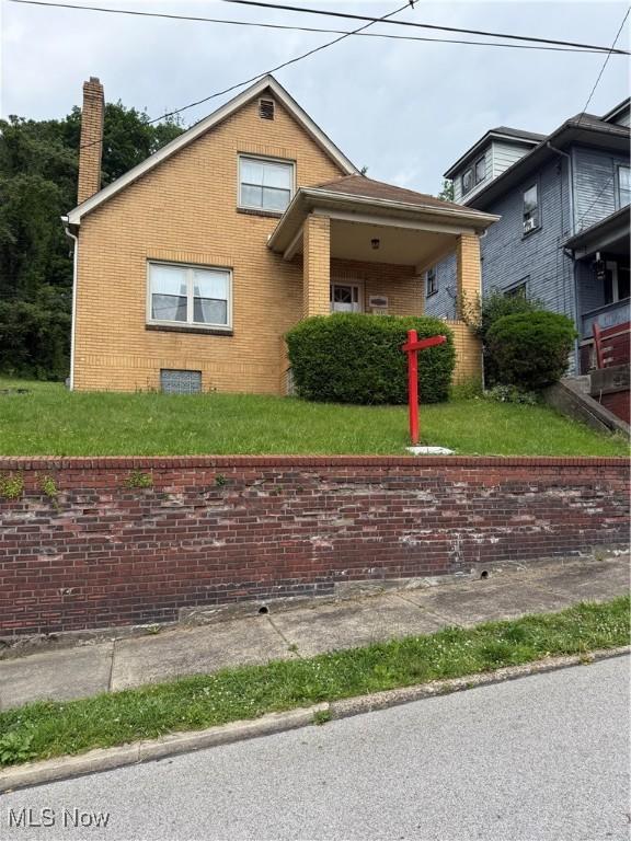 3427 Elm St, Weirton, WV 26062 - view of front of home with brick siding, a chimney, and a front yard