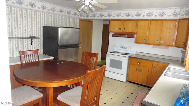 521 Georgia Ave, Chester, WV 26034 - kitchen featuring white range with electric stovetop, freestanding refrigerator, a ceiling fan, wallpapered walls, and brown cabinets
