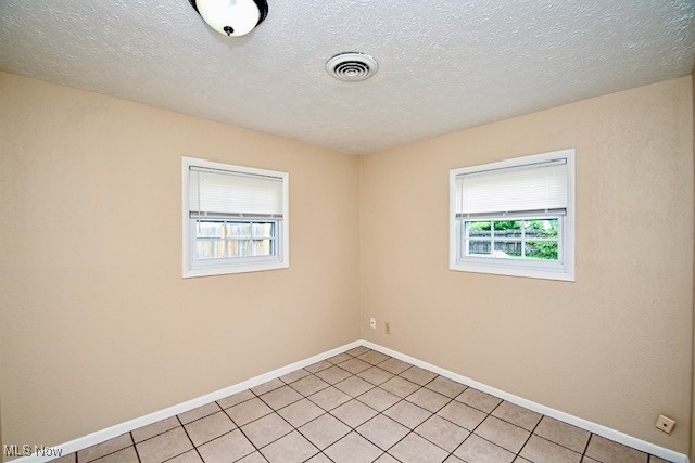 2312 Midway Ave NE, Canton, OH 44705 - empty room featuring light tile patterned flooring, baseboards, and a textured ceiling