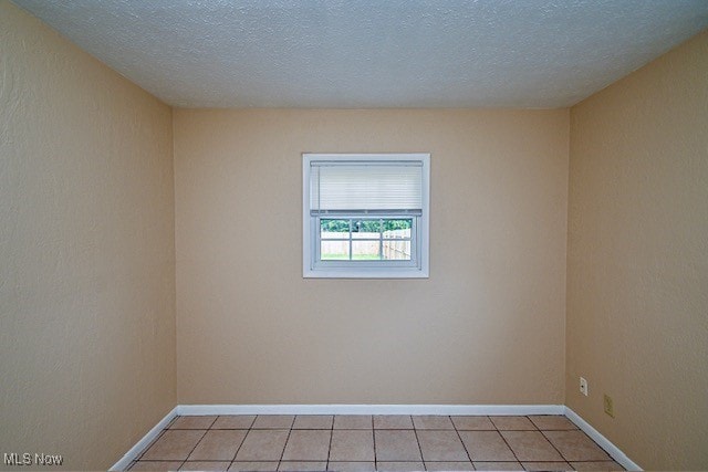 2312 Midway Ave NE, Canton, OH 44705 - spare room featuring light tile patterned floors, baseboards, and a textured ceiling