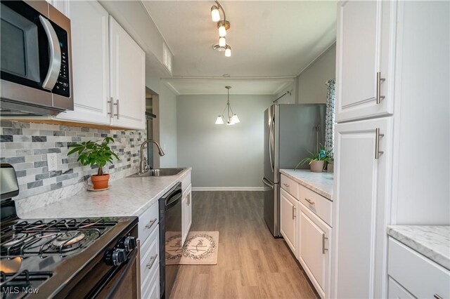 117 N Navarre Ave, Youngstown, OH 44515 - kitchen with black appliances, a sink, light wood-style floors, backsplash, and white cabinetry