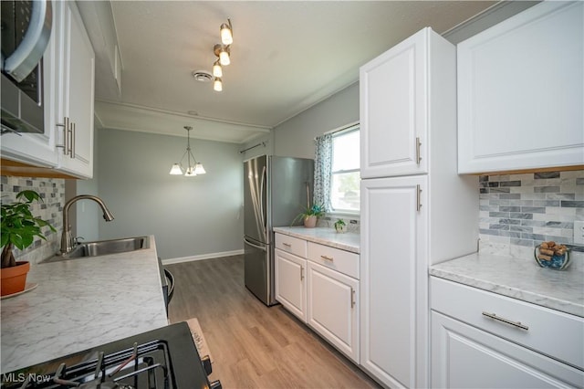 117 N Navarre Ave, Youngstown, OH 44515 - kitchen featuring freestanding refrigerator, a sink, decorative backsplash, white cabinets, and light countertops