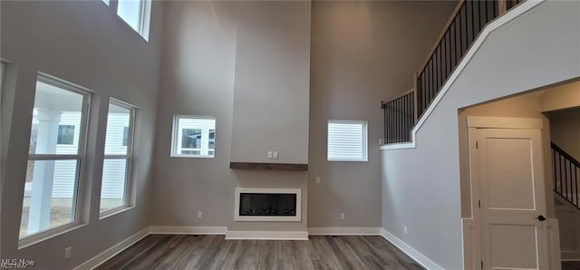 9145 Ledge View Ter, Broadview Heights, OH 44147 - unfurnished living room with a towering ceiling, stairs, dark wood-type flooring, and baseboards