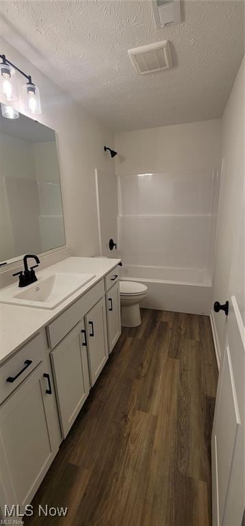 9135 Ledge View Ter, Broadview Heights, OH 44147 - full bath with vanity, toilet, wood finished floors, a textured ceiling, and washtub / shower combination