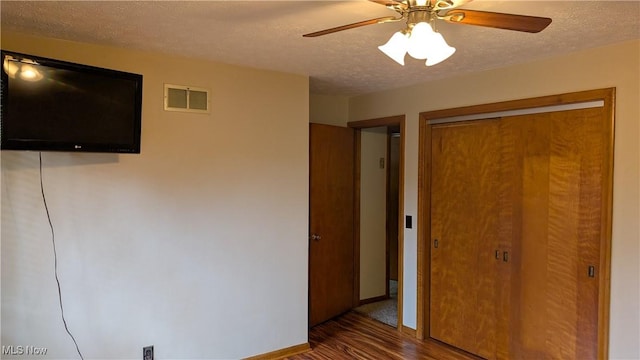 2615 Orchard Park St NW, Canton, OH 44718 - unfurnished bedroom with a textured ceiling, wood finished floors, a closet, baseboards, and a ceiling fan