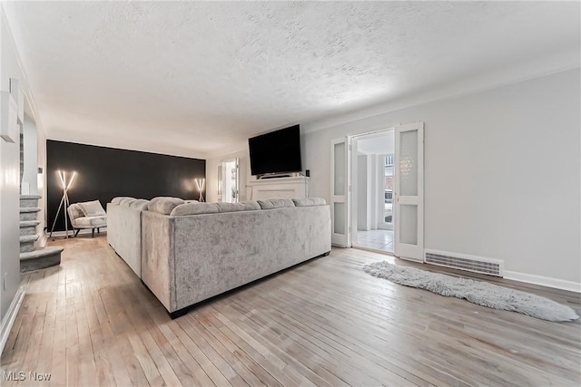 17314 Lomond Blvd, Shaker Heights, OH 44120 - living room featuring light wood finished floors, a textured ceiling, and stairs