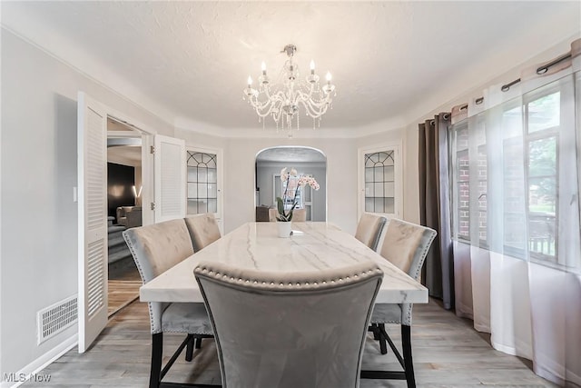 17314 Lomond Blvd, Shaker Heights, OH 44120 - dining room featuring arched walkways, a chandelier, and light wood-style floors