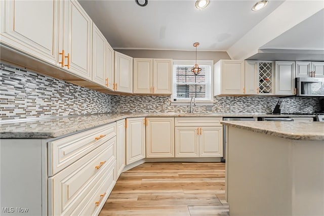 17314 Lomond Blvd, Shaker Heights, OH 44120 - kitchen featuring stainless steel microwave, light wood-style floors, light stone countertops, decorative backsplash, and pendant lighting