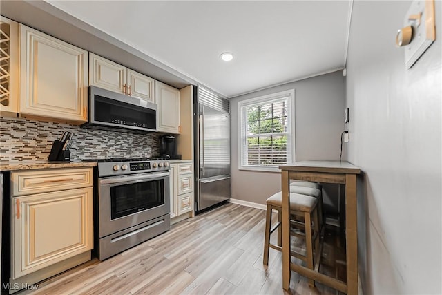 17314 Lomond Blvd, Shaker Heights, OH 44120 - kitchen with appliances with stainless steel finishes, cream cabinets, tasteful backsplash, light wood-type flooring, and recessed lighting
