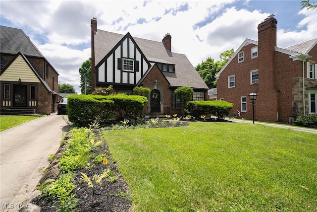 17314 Lomond Blvd, Shaker Heights, OH 44120 - tudor-style house featuring a front lawn, a chimney, and a shingled roof