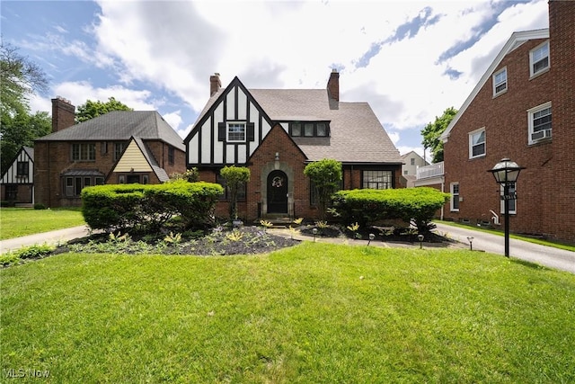 17314 Lomond Blvd, Shaker Heights, OH 44120 - english style home featuring a front lawn, a chimney, and brick siding