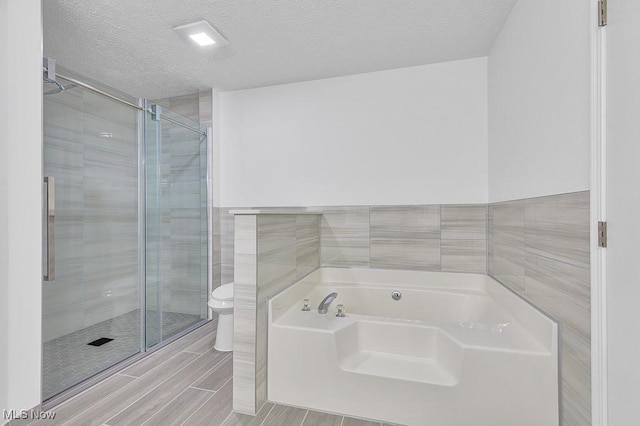 8000 Lake Rd, Seville, OH 44273 - full bath with tile walls, toilet, a bath, a stall shower, and a textured ceiling