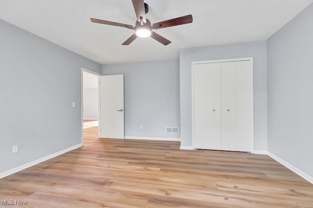 8000 Lake Rd, Seville, OH 44273 - unfurnished bedroom featuring light wood-style flooring, baseboards, a closet, and a ceiling fan