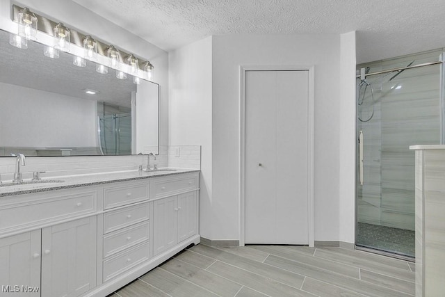 8000 Lake Rd, Seville, OH 44273 - full bath featuring a shower stall, double vanity, a textured ceiling, and wood tiled floors