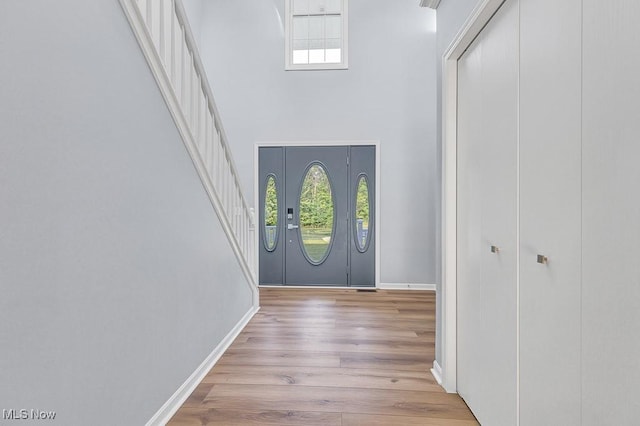 8000 Lake Rd, Seville, OH 44273 - entrance foyer featuring healthy amount of natural light, a high ceiling, light wood finished floors, baseboards, and stairs