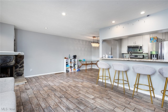 28140 Detroit Rd Unit D3, Westlake, OH 44145 - kitchen featuring appliances with stainless steel finishes, wood finished floors, recessed lighting, a breakfast bar, and baseboards