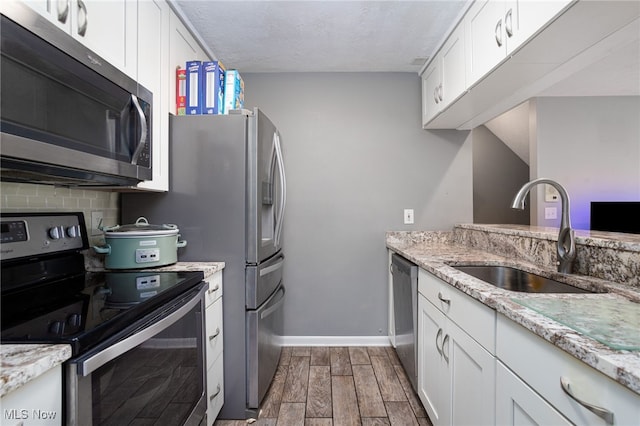 28140 Detroit Rd Unit D3, Westlake, OH 44145 - kitchen featuring stainless steel appliances, a sink, dark wood-style floors, white cabinetry, and baseboards