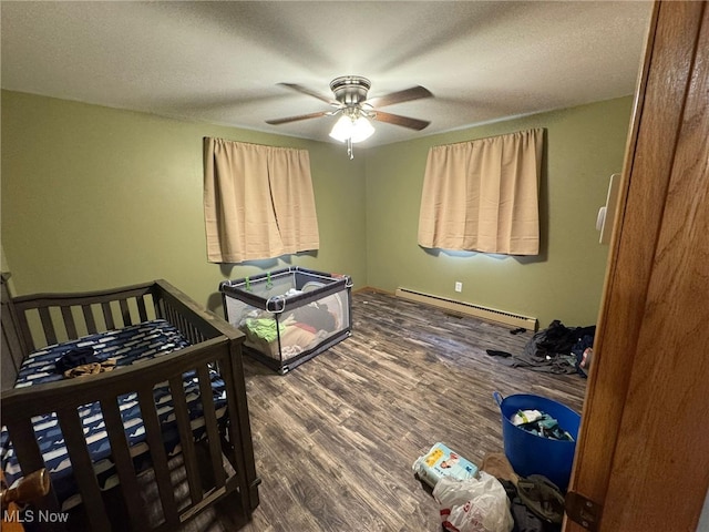 85 Arrow Rd NW, Carrollton, OH 44615 - bedroom with a baseboard heating unit, dark wood finished floors, a ceiling fan, and a textured ceiling