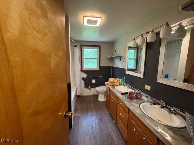 85 Arrow Rd NW, Carrollton, OH 44615 - bathroom featuring double vanity, toilet, wood finished floors, and shower / tub combo
