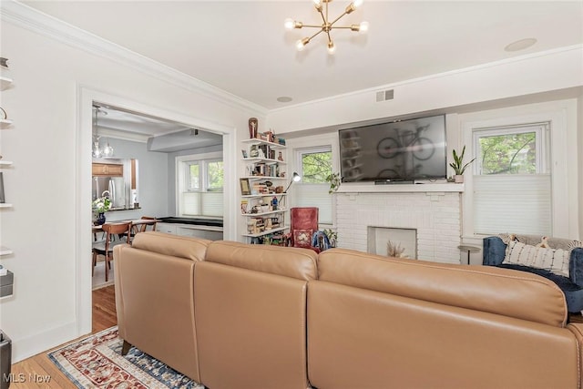 2725 Hampshire Rd Unit 2, Cleveland Heights, OH 44106 - living area featuring a chandelier, wood finished floors, crown molding, plenty of natural light, and a brick fireplace