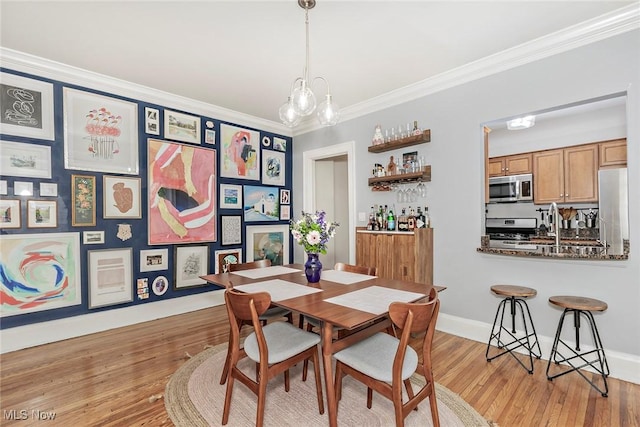 2725 Hampshire Rd Unit 2, Cleveland Heights, OH 44106 - dining space with ornamental molding, wood finished floors, a chandelier, and baseboards